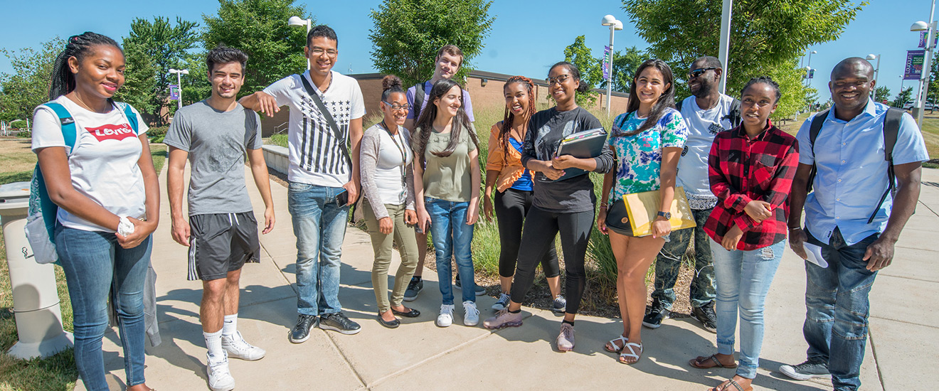 A group of NOVA students standing on campus smiling