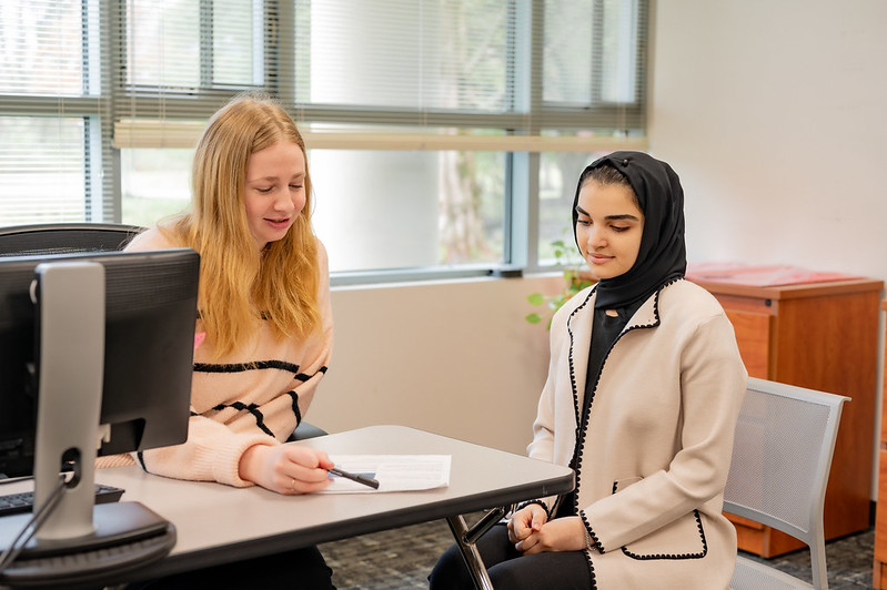 an advisor and a student sitting at a desk